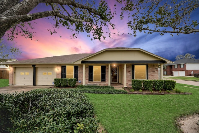 ranch-style home featuring a yard, covered porch, and a garage