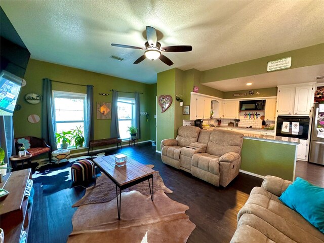 living room with dark hardwood / wood-style flooring, a textured ceiling, and ceiling fan