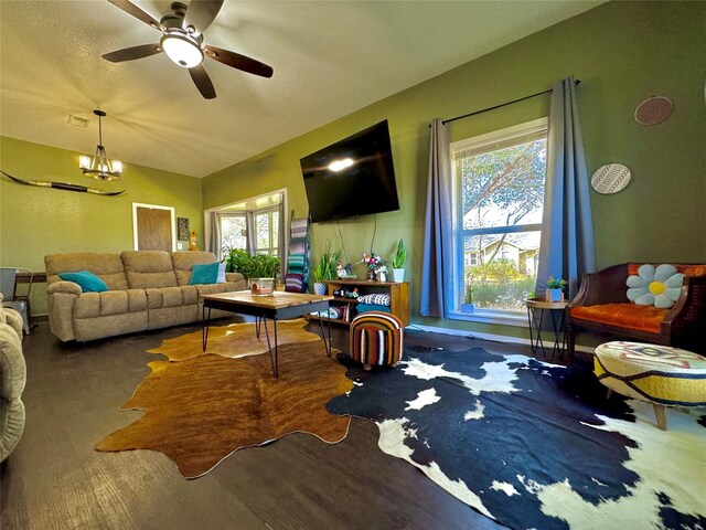 living room featuring ceiling fan with notable chandelier and wood-type flooring