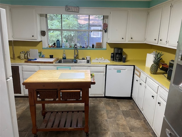 kitchen with plenty of natural light, white appliances, sink, and white cabinetry