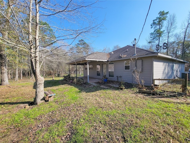 rear view of house featuring a lawn and a patio area