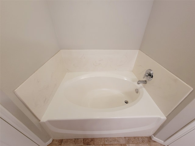 bathroom featuring tile floors and a bath