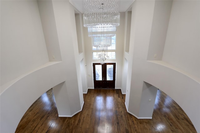 entrance foyer with dark wood-style floors, a high ceiling, baseboards, and a notable chandelier