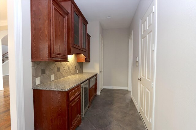 kitchen featuring decorative backsplash, dark hardwood / wood-style floors, light stone counters, and wine cooler