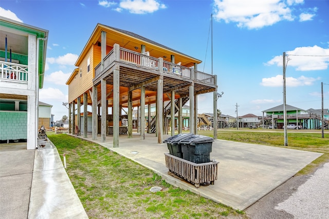 back of house featuring a balcony and a yard