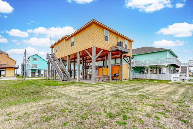 rear view of property featuring a wooden deck, a patio, and a yard