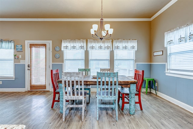 dining room with a chandelier, crown molding, and light hardwood / wood-style flooring