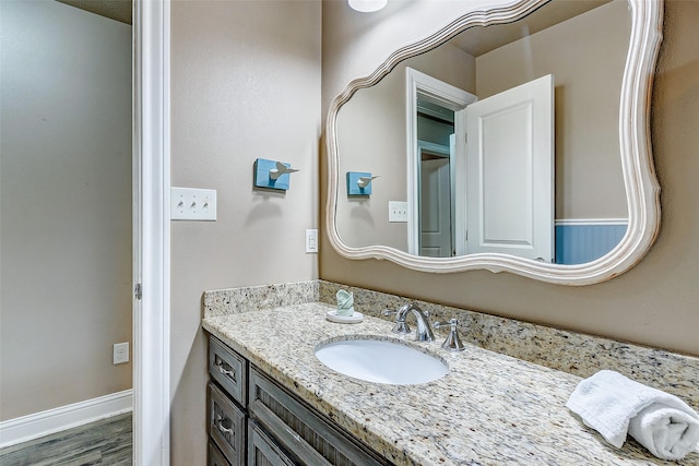 bathroom featuring wood-type flooring and vanity with extensive cabinet space