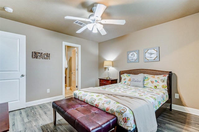 bedroom with ensuite bathroom, hardwood / wood-style floors, and ceiling fan