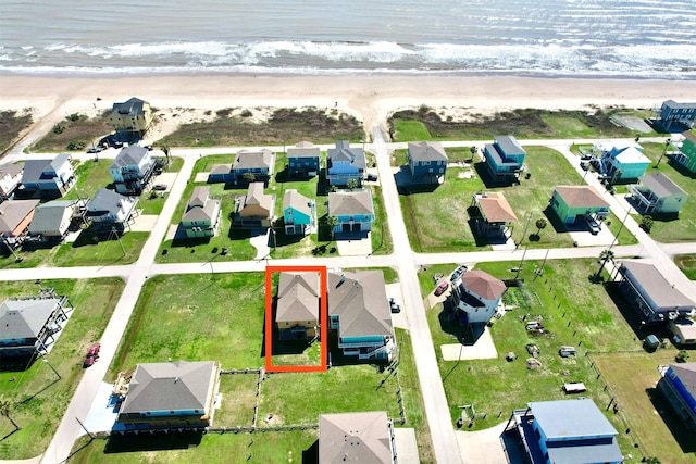 birds eye view of property featuring a beach view and a water view