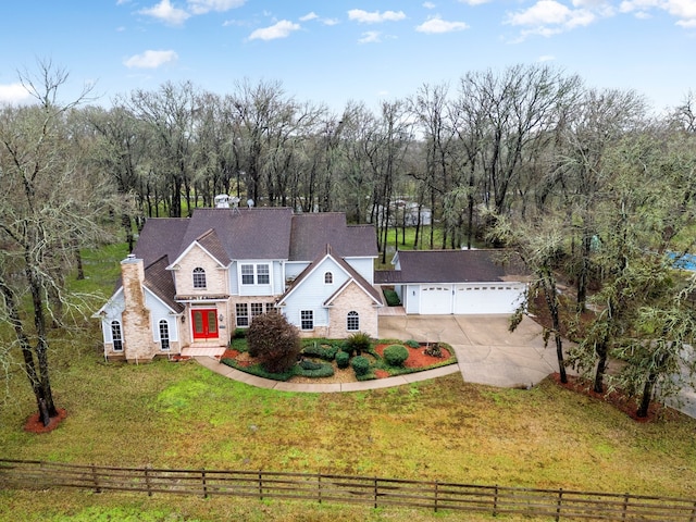 view of front facade with a front lawn, a rural view, and a garage