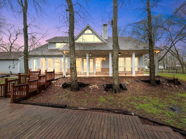 back house at dusk with a deck