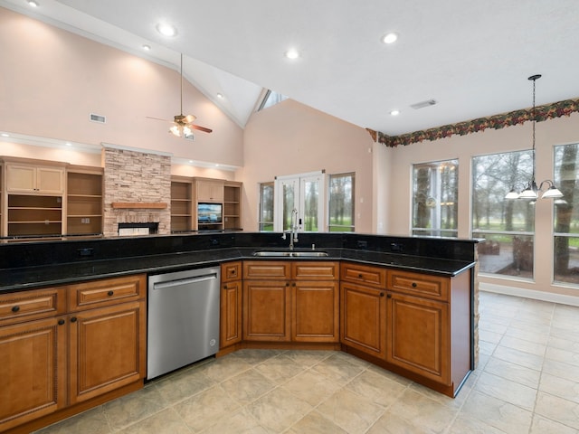 kitchen with stainless steel dishwasher, sink, ceiling fan, and dark stone counters