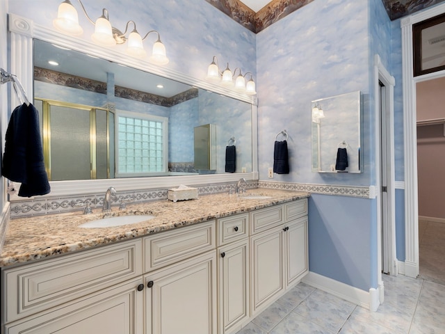 bathroom with dual sinks, tile floors, large vanity, and a shower with shower door