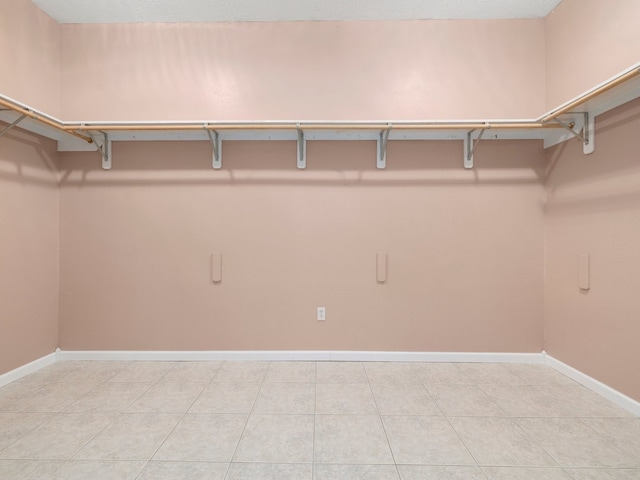 spacious closet with light tile floors