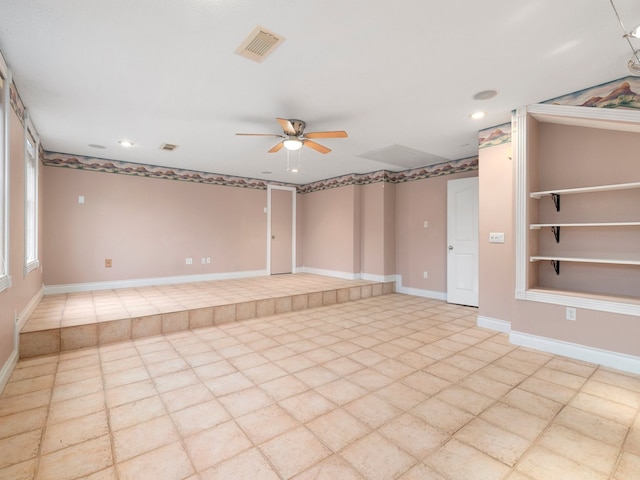 tiled empty room featuring ceiling fan