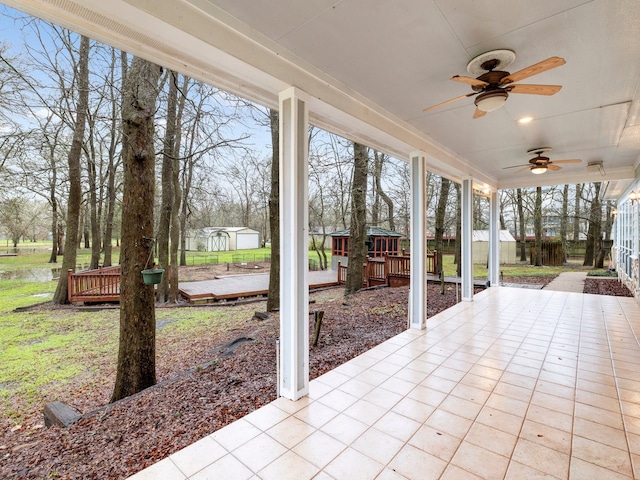 unfurnished sunroom with ceiling fan