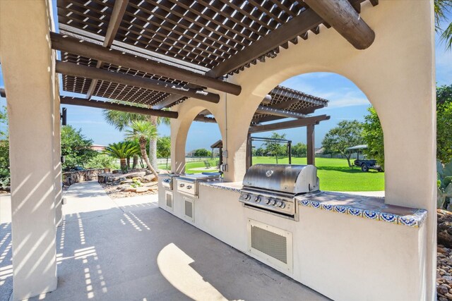 view of patio featuring a pergola, exterior kitchen, and grilling area