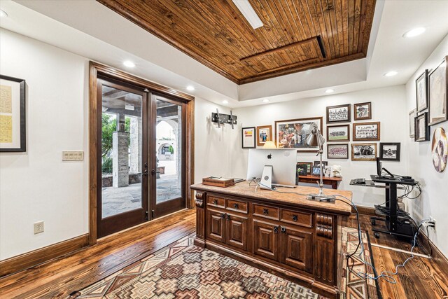 office with a tray ceiling, dark hardwood / wood-style flooring, wooden ceiling, and french doors