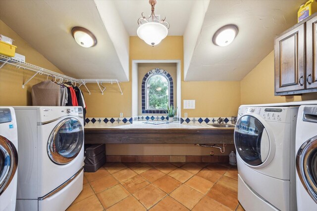 washroom featuring washing machine and clothes dryer, sink, and cabinets