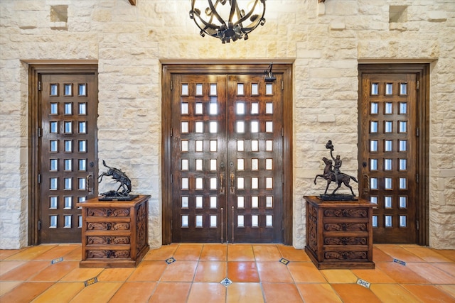 tiled entrance foyer with a chandelier