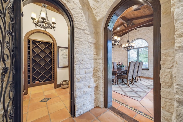 wine cellar featuring tile patterned floors, lofted ceiling with beams, wooden ceiling, and a chandelier