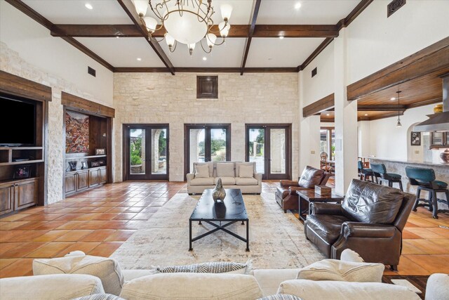 tiled living room with beamed ceiling, a chandelier, a towering ceiling, and french doors