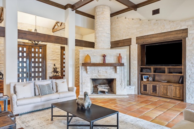 tiled living room with beam ceiling, a stone fireplace, crown molding, and a high ceiling