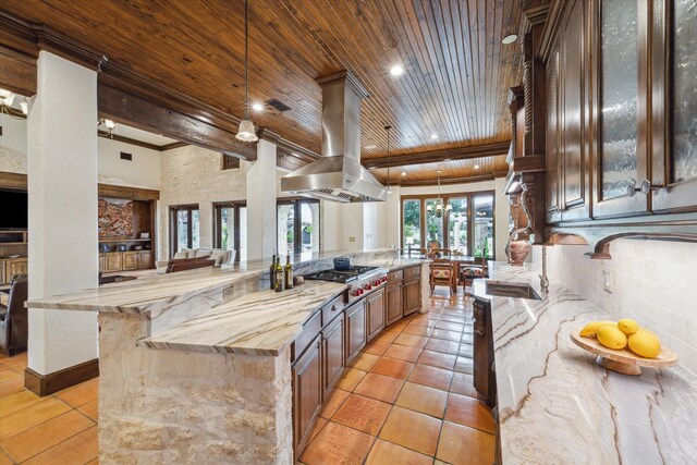 kitchen with wooden ceiling, decorative light fixtures, beam ceiling, island exhaust hood, and stainless steel gas cooktop