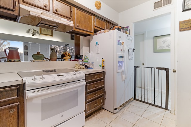 kitchen with light tile floors, white appliances, and custom exhaust hood