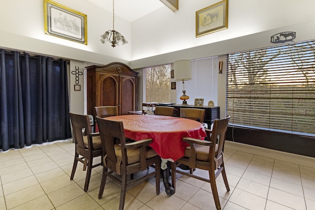 tiled dining space featuring a high ceiling, a notable chandelier, and beam ceiling