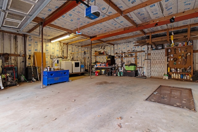 garage with a garage door opener, a workshop area, and washer and clothes dryer