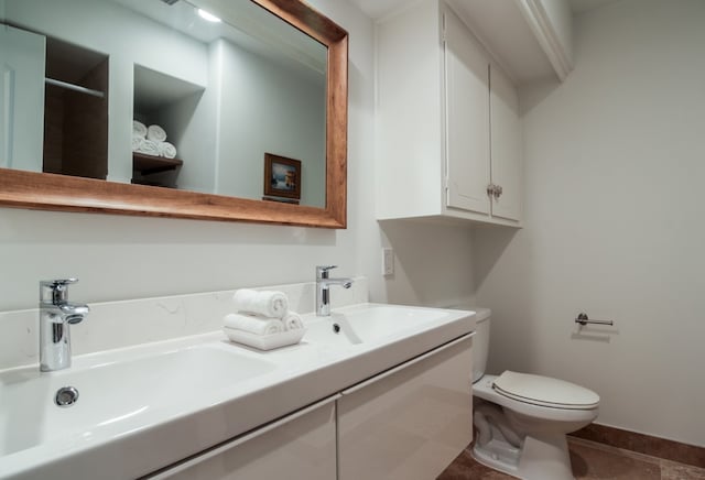 bathroom featuring tile patterned flooring, vanity, and toilet