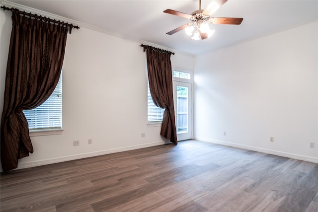 unfurnished room featuring hardwood / wood-style flooring, a wealth of natural light, crown molding, and ceiling fan