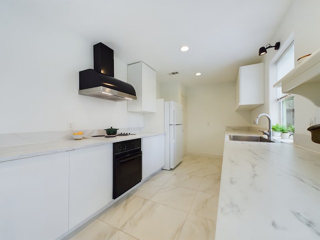 kitchen with white refrigerator, white cabinetry, oven, and wall chimney range hood