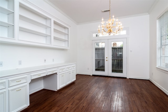 unfurnished office with french doors, dark hardwood / wood-style flooring, a chandelier, built in desk, and ornamental molding