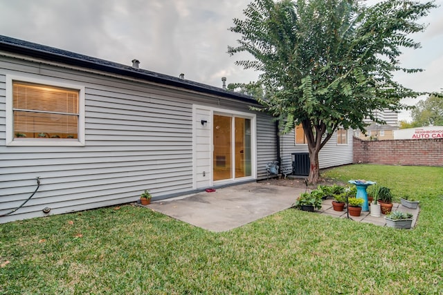 back of house featuring a lawn, a patio, and central AC