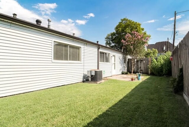 rear view of house featuring central AC, a patio area, and a yard