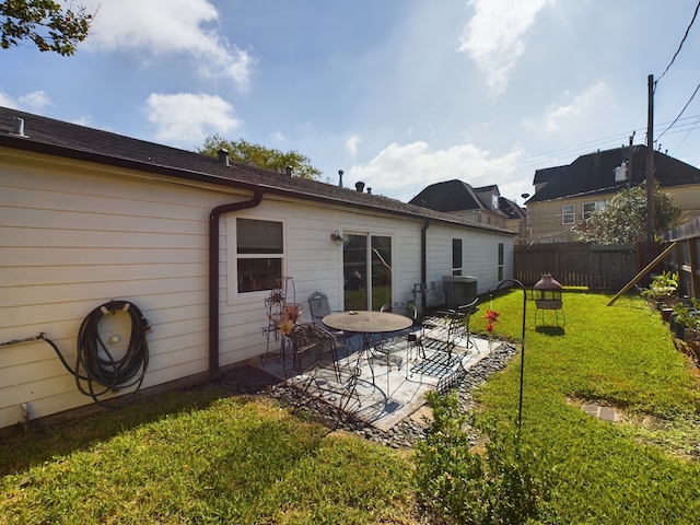 rear view of property featuring a patio area and a yard