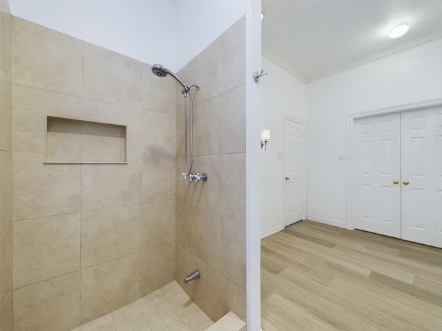 bathroom featuring crown molding, hardwood / wood-style floors, and tiled shower