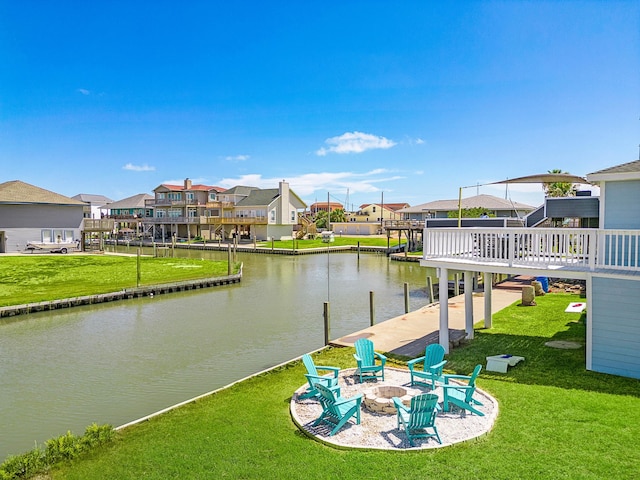 view of dock featuring a water view, a yard, and an outdoor fire pit