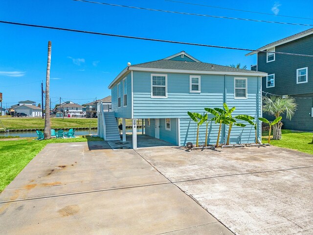 back of house featuring a yard and a water view