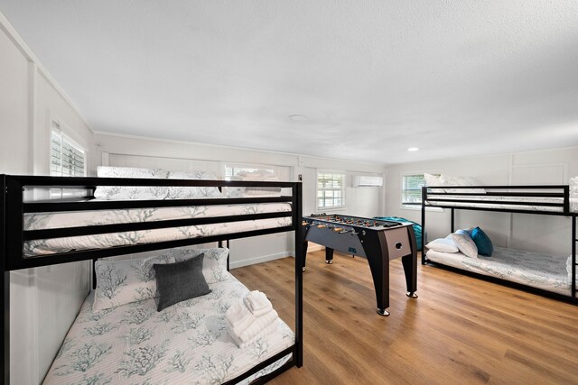 bedroom featuring a wall mounted air conditioner and light hardwood / wood-style floors