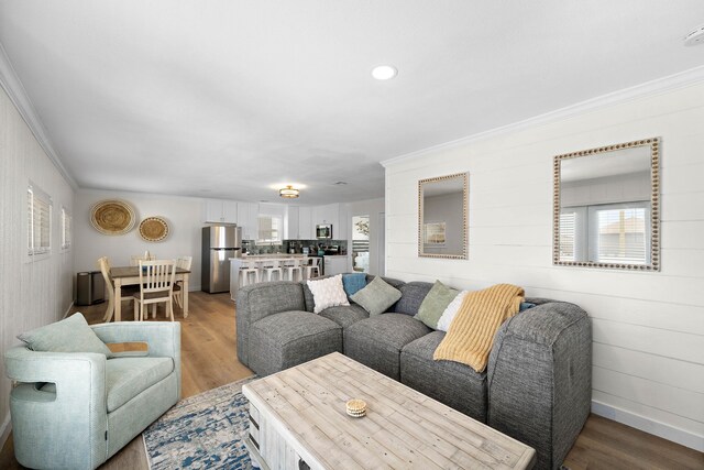 living room with crown molding and light hardwood / wood-style flooring