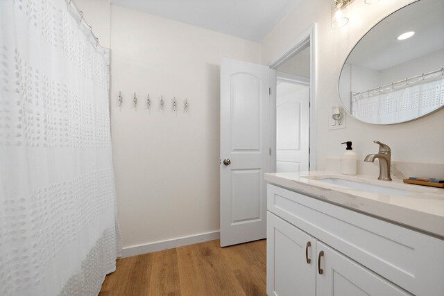 bathroom featuring walk in shower, wood-type flooring, and vanity