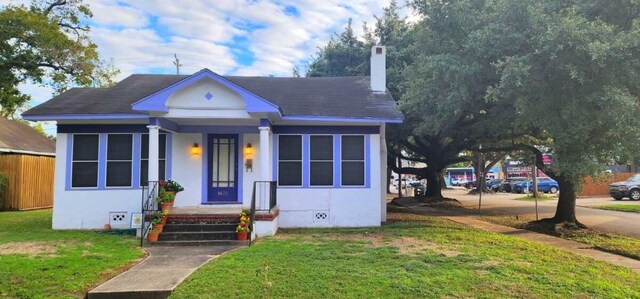 bungalow-style home with a front lawn