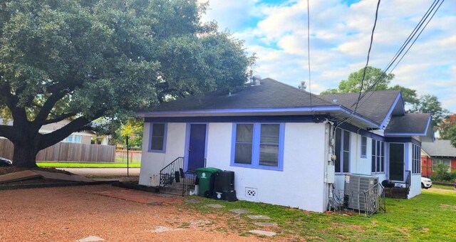 view of side of home with central AC