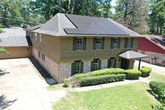 view of front of house with a front lawn and solar panels