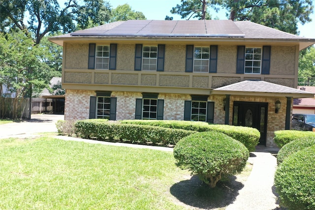 view of front facade with a front lawn and solar panels