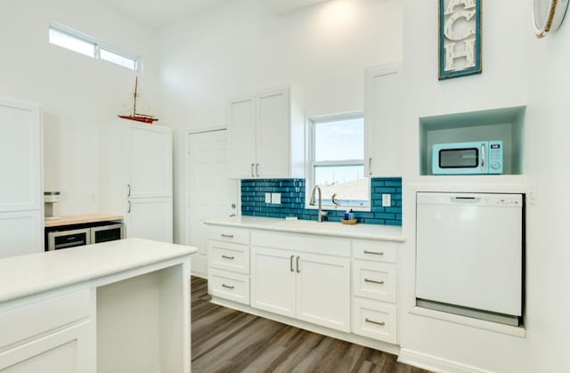 kitchen featuring white cabinets, backsplash, white appliances, sink, and dark hardwood / wood-style floors